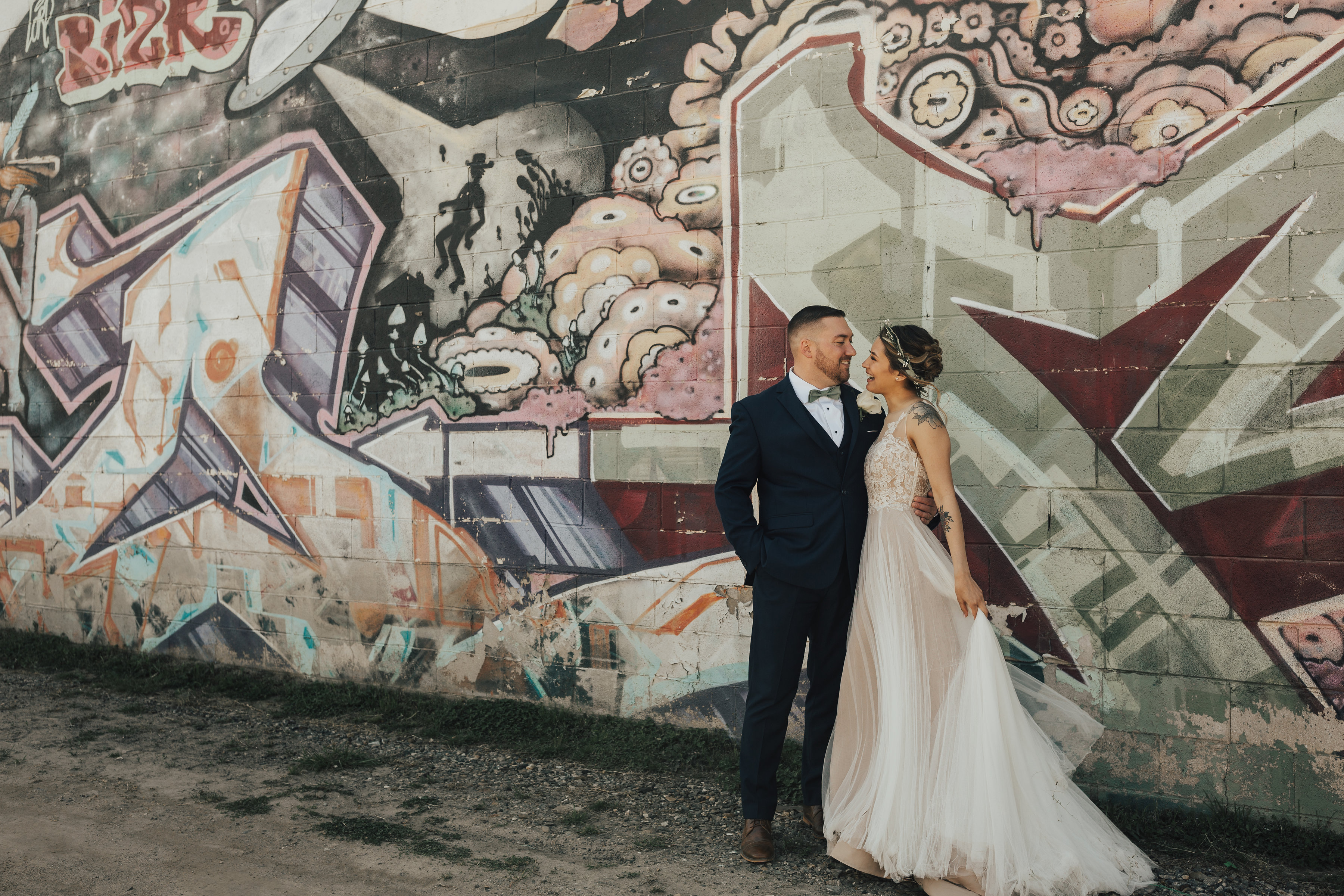 married couple standing near painted wall